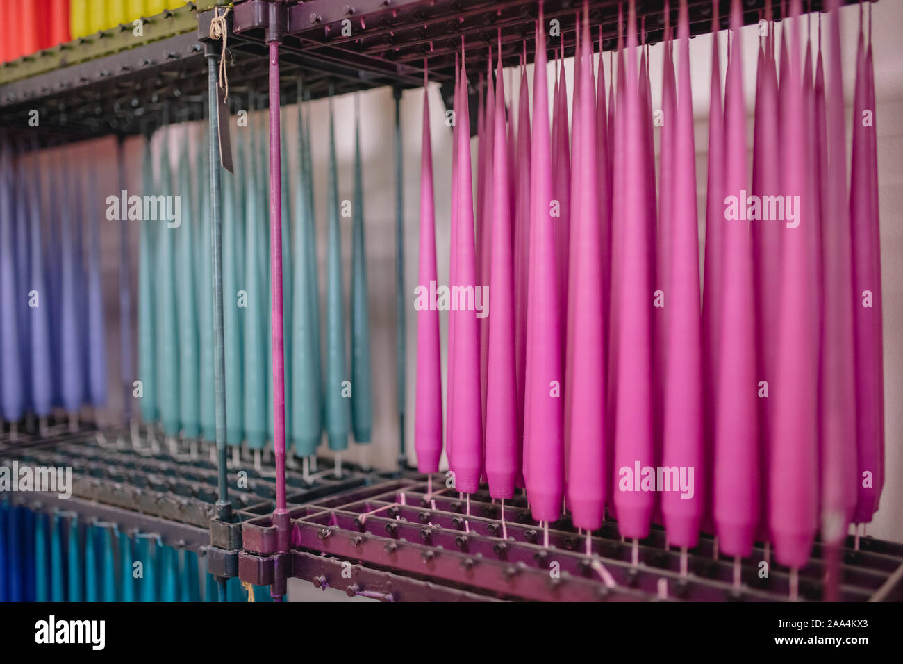 Process of making and drying wax candles on stand is vertical. Stock Photo