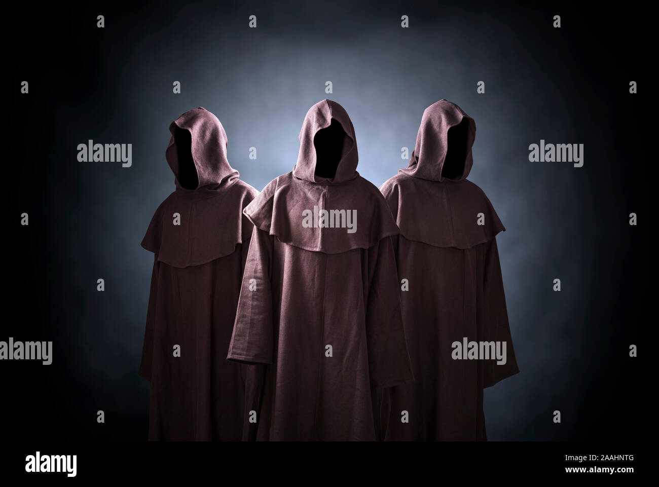 Group of three scary figures in hooded cloaks Stock Photo