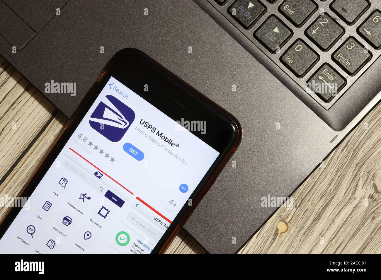 Los Angeles, California, USA - 3 December 2019: USPS Mobile App Logo on phone screen with laptop flat lay, Illustrative Editorial. Stock Photo