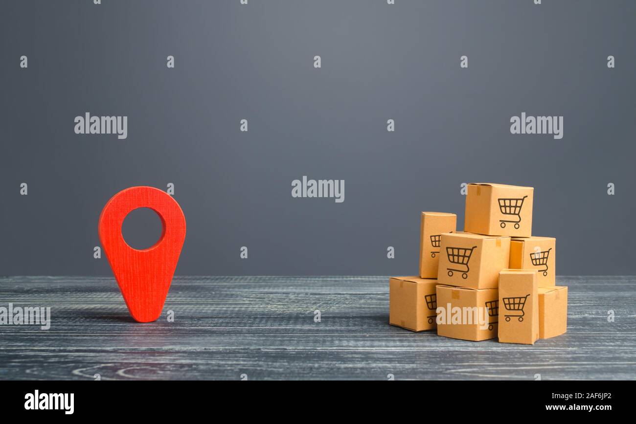 Red location pointer geolocation symbol and cardboard boxes. Distribution delivery of goods, freight transportation shipment. Logistics and warehousin Stock Photo