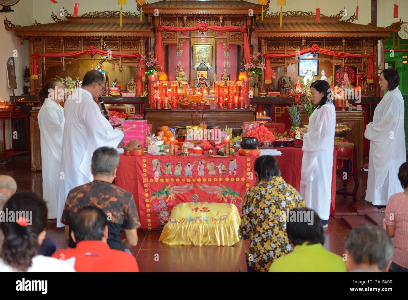 A group of monks with white cloaks prepare a ceremony in a Buddhist Temple before Chinese New Year celebration. Stock Photo