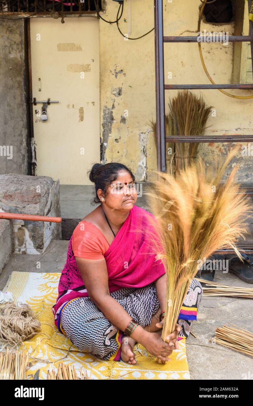 Indian woman making brooms in Dharavi Slum at Mumbai. India Stock Photo