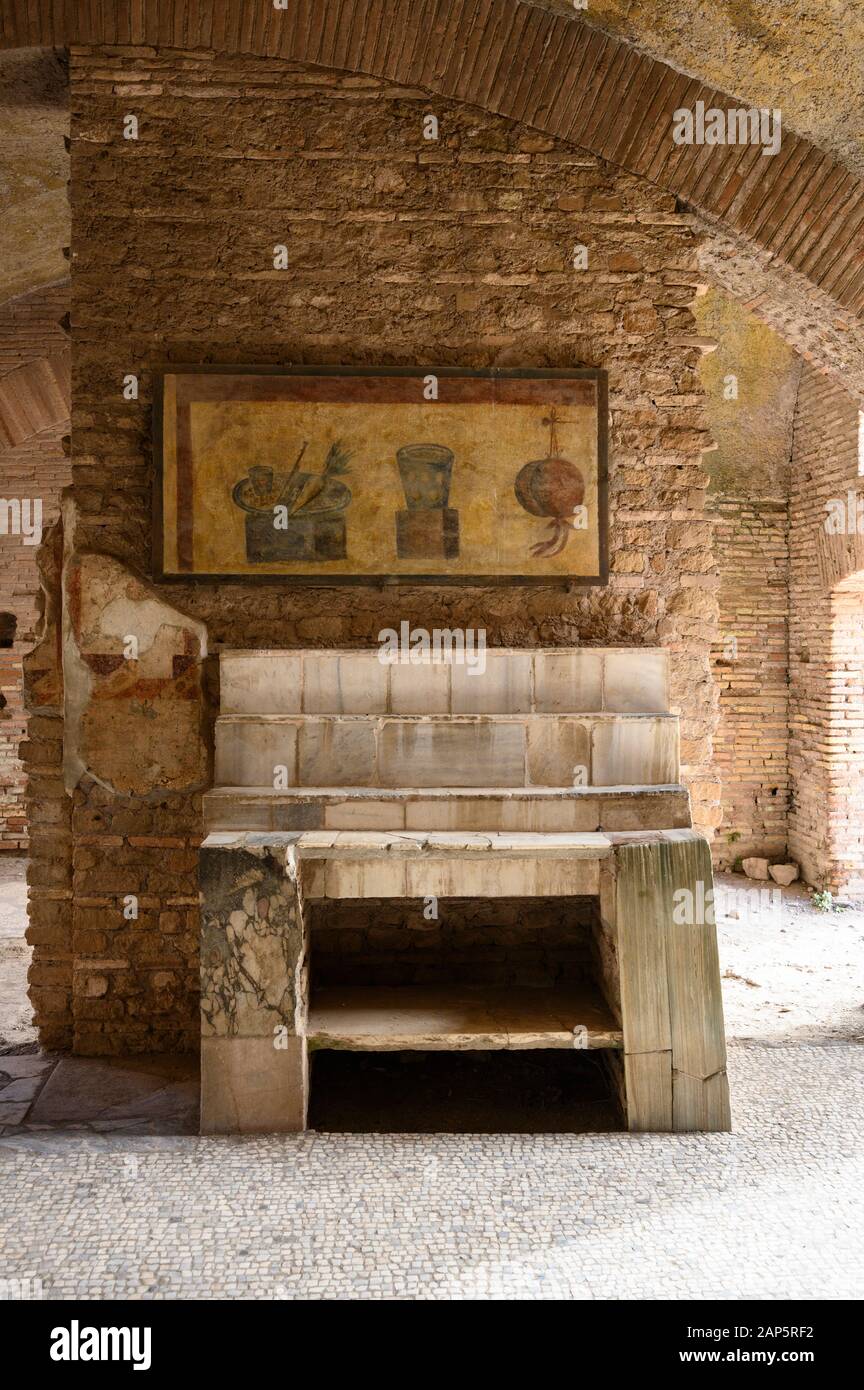 Rome. Italy. Ostia Antica. Caseggiato del Termopolio, Thermopolium (House of the Bar). Side table and shelves, above which is a painting depicting foo Stock Photo