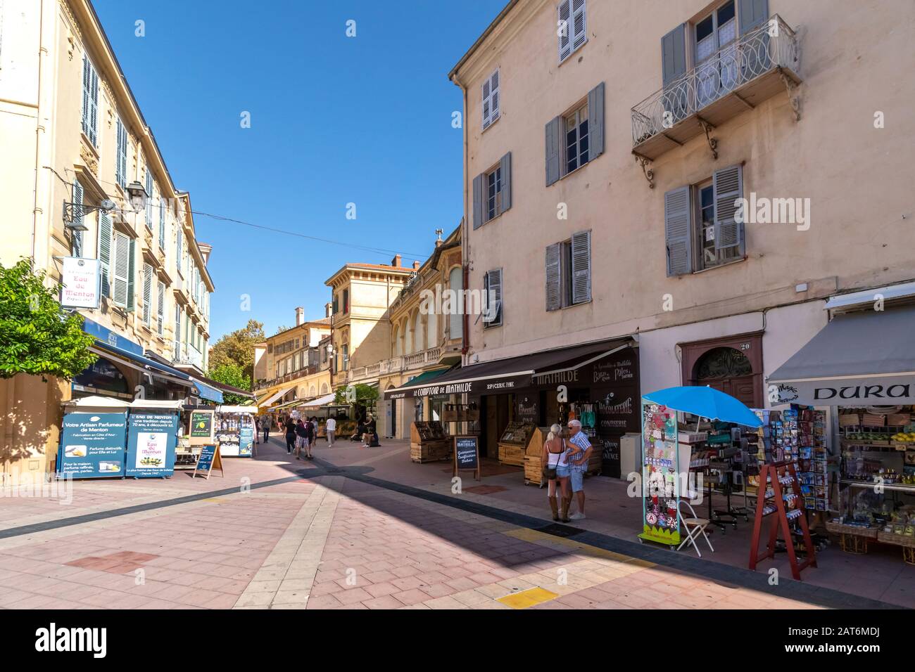 A sunny day as tourists dine at cafes and shop for souvenirs in the resort seaside town of Menton France on the French Riviera. Stock Photo