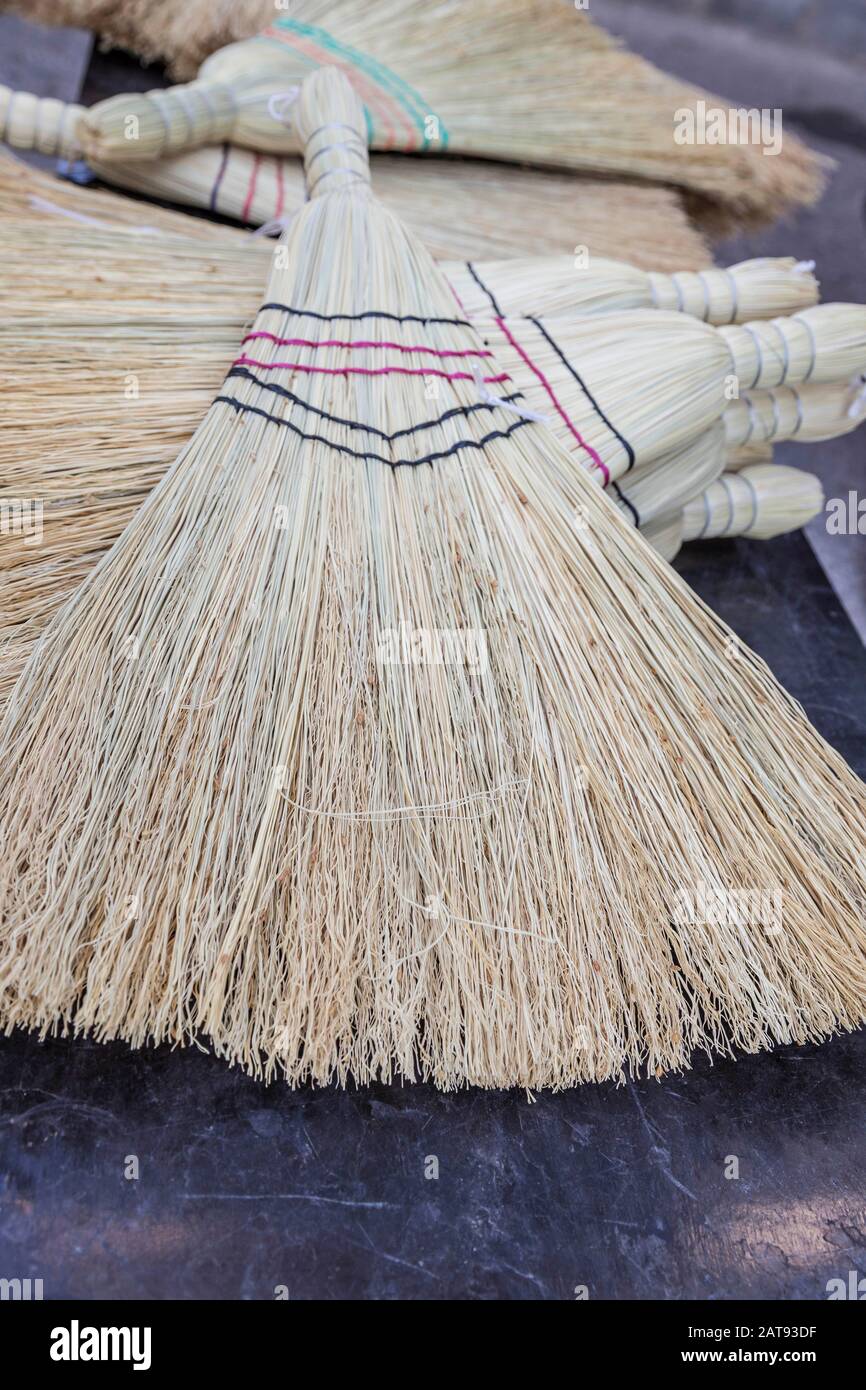 closeup pile of vintage straw brooms Stock Photo