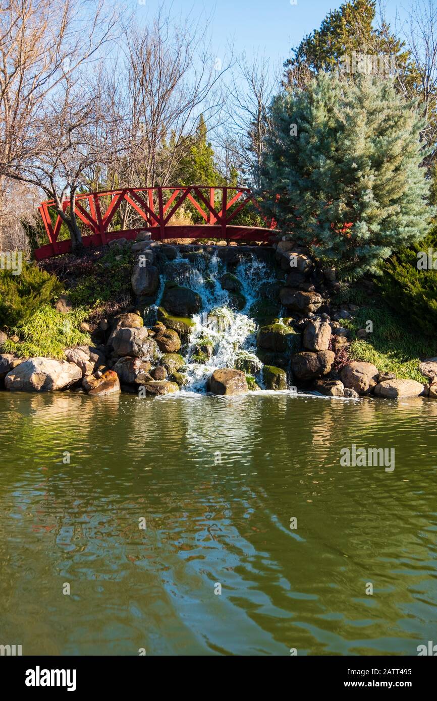 A water attraction of a small truss footbridge and waterfall by a small lake at Bradley Fair shopping center in Wichita, Kansas, USA. Stock Photo