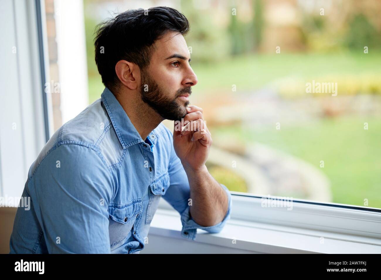 Man looking out of window Stock Photo