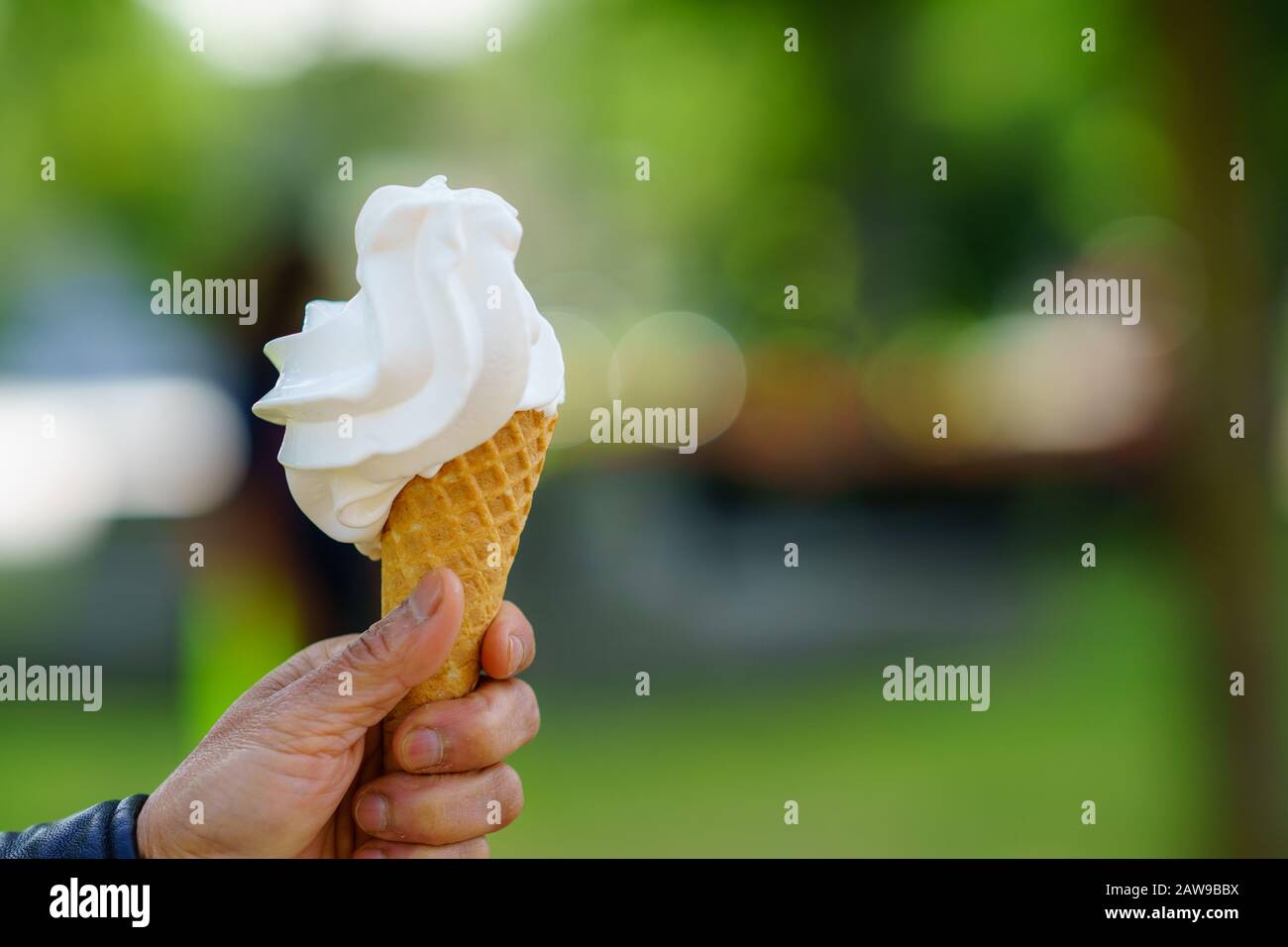 Hand holding ice cream cone. Vanilla ice cream Stock Photo