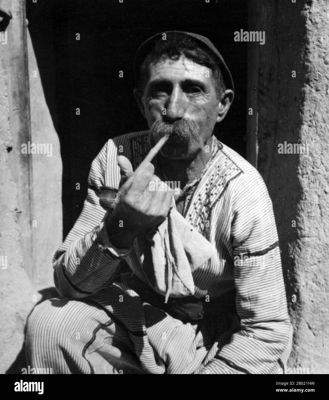 Syria: Assyrian refugee in traditional garb, Tell-Tamar, northeastern Syria, 1939.  The Assyrian people, most commonly known as Assyrians and other later names such as Ashuriyun, Atorayeh and Syriacs, are a distinct ethnic group whose origins lie in ancient Mesopotamia. They are a Semitic people, who speak and write distinct dialects of Eastern Aramaic exclusive to Mesopotamia and its immediate surrounds.  Assyrians trace their ancestry back to the Sumero-Akkadian civilisation that emerged in Mesopotamia circa 4000–3500 BCE. Stock Photo