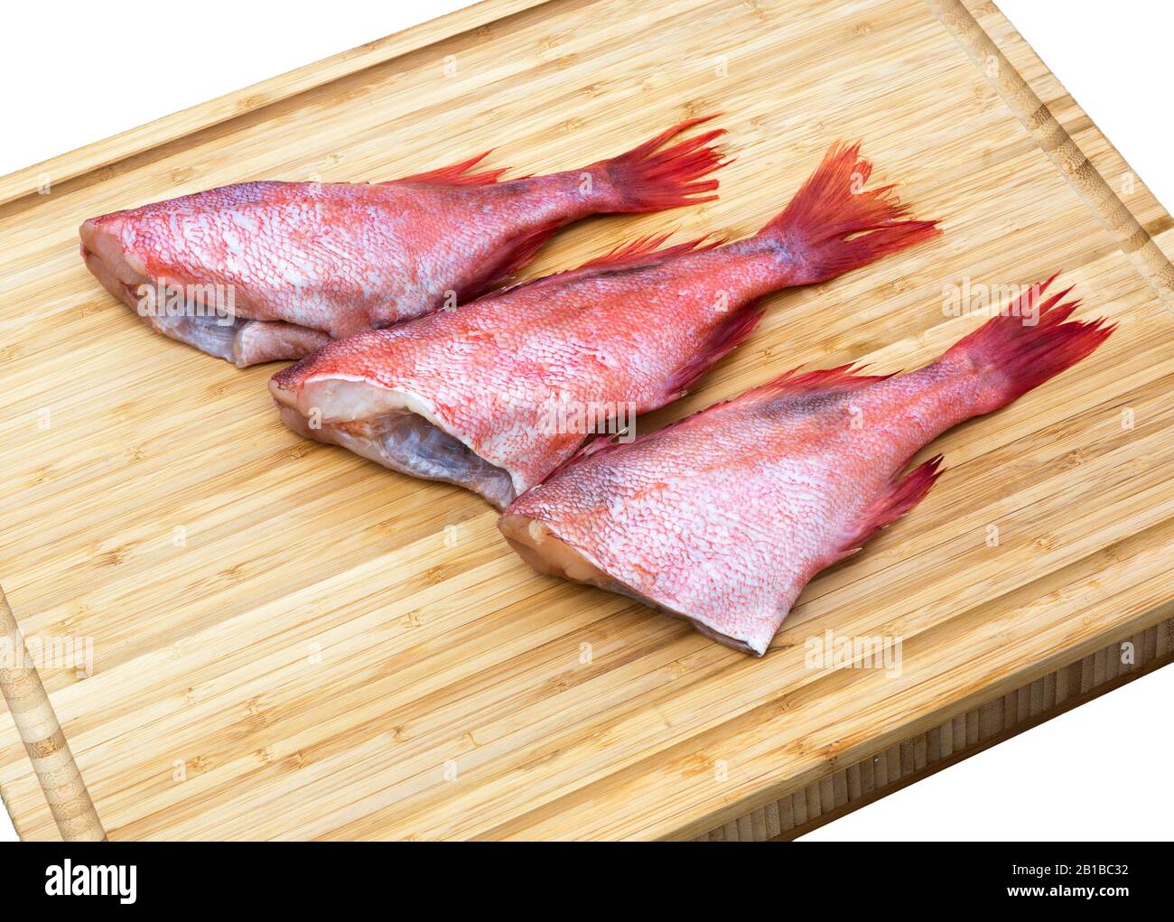 Fresh raw red fish on wooden cutting board. Raw red sea perches. Fish wooden chopping board. Stock Photo