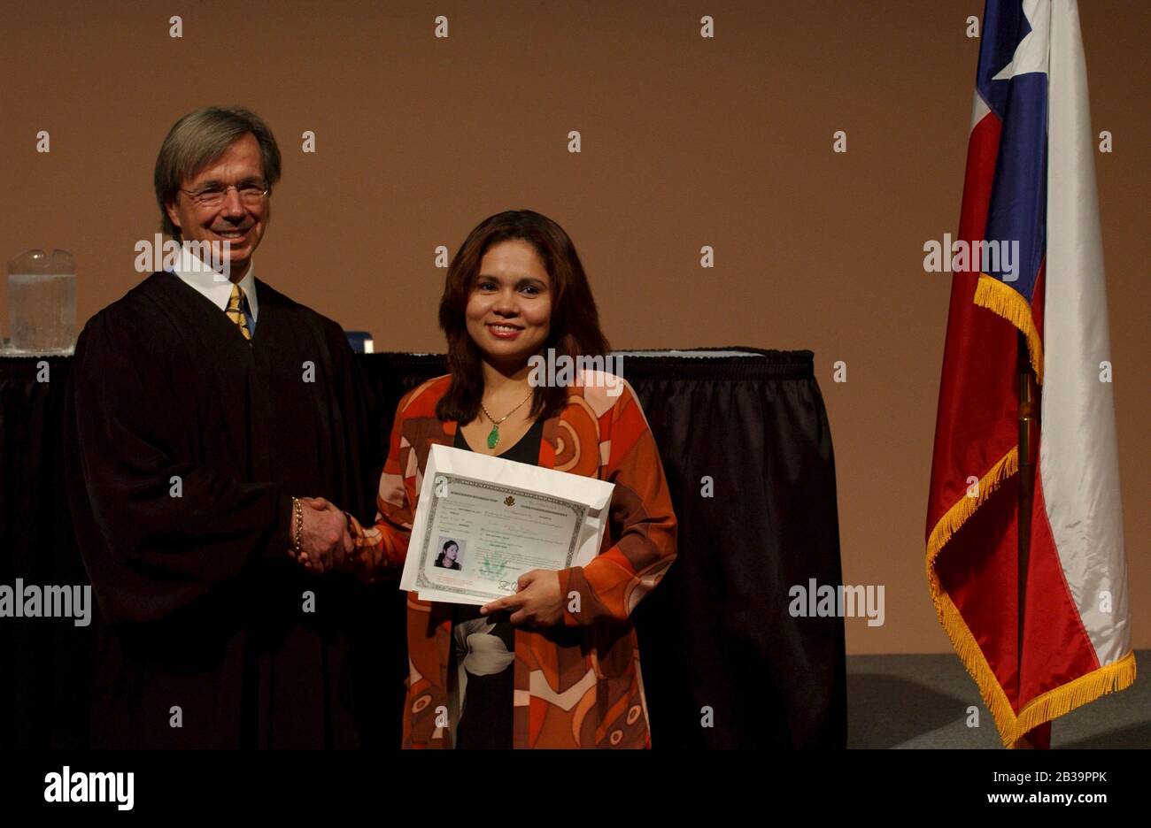 San Antonio Texas USA, April 18, 2004: New U.S. citizen is congratulated by  U.S. Federal Judge John W. Primono during naturalization ceremony at the Institute of Texan Cultures. ©Bob Daemmrich Stock Photo