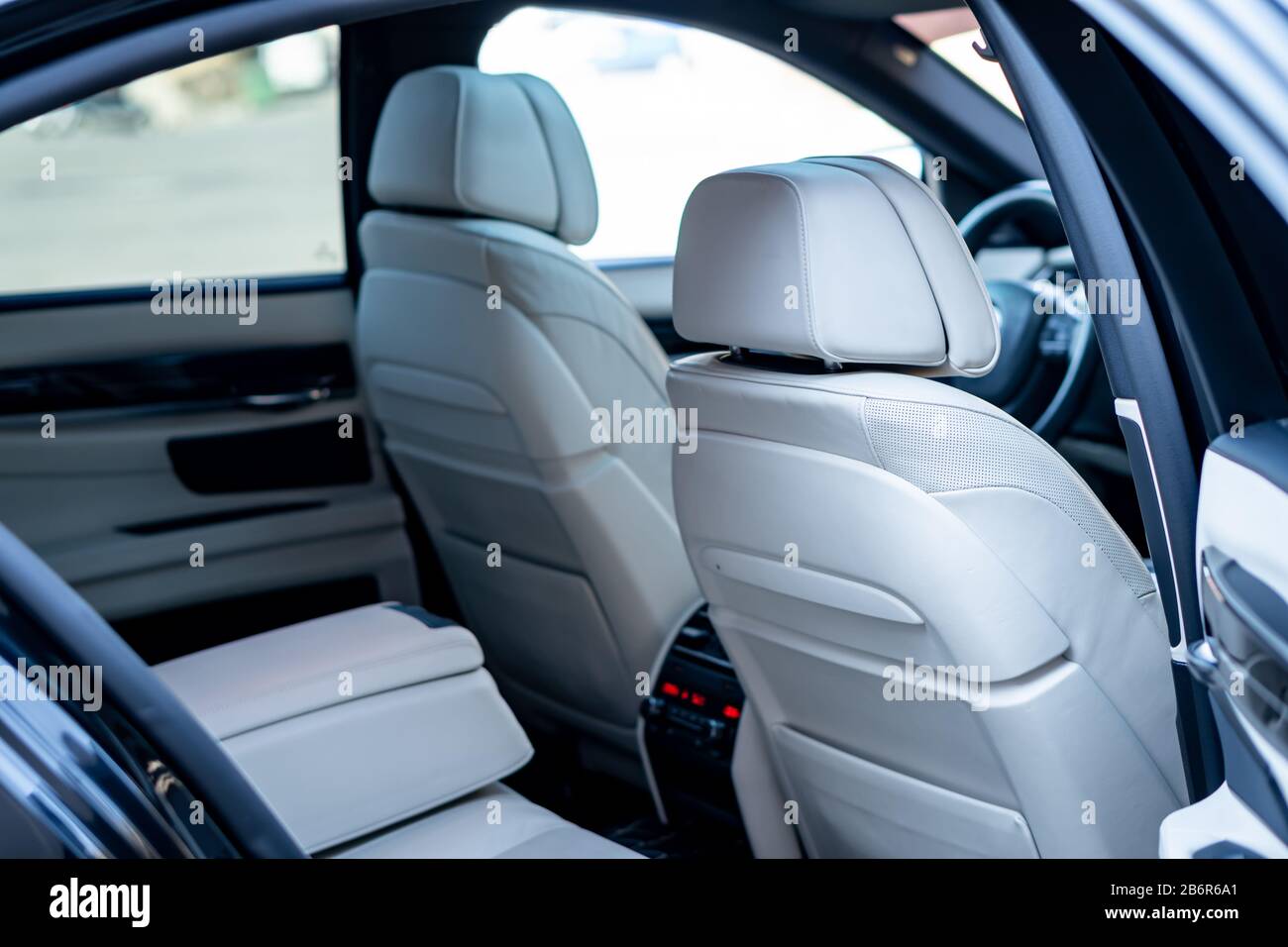 White leather interior seats and dashboard inside a luxurious BMW 750d black limousine with 381hp, hi-tech comfort equipment. M Package and Individual Stock Photo