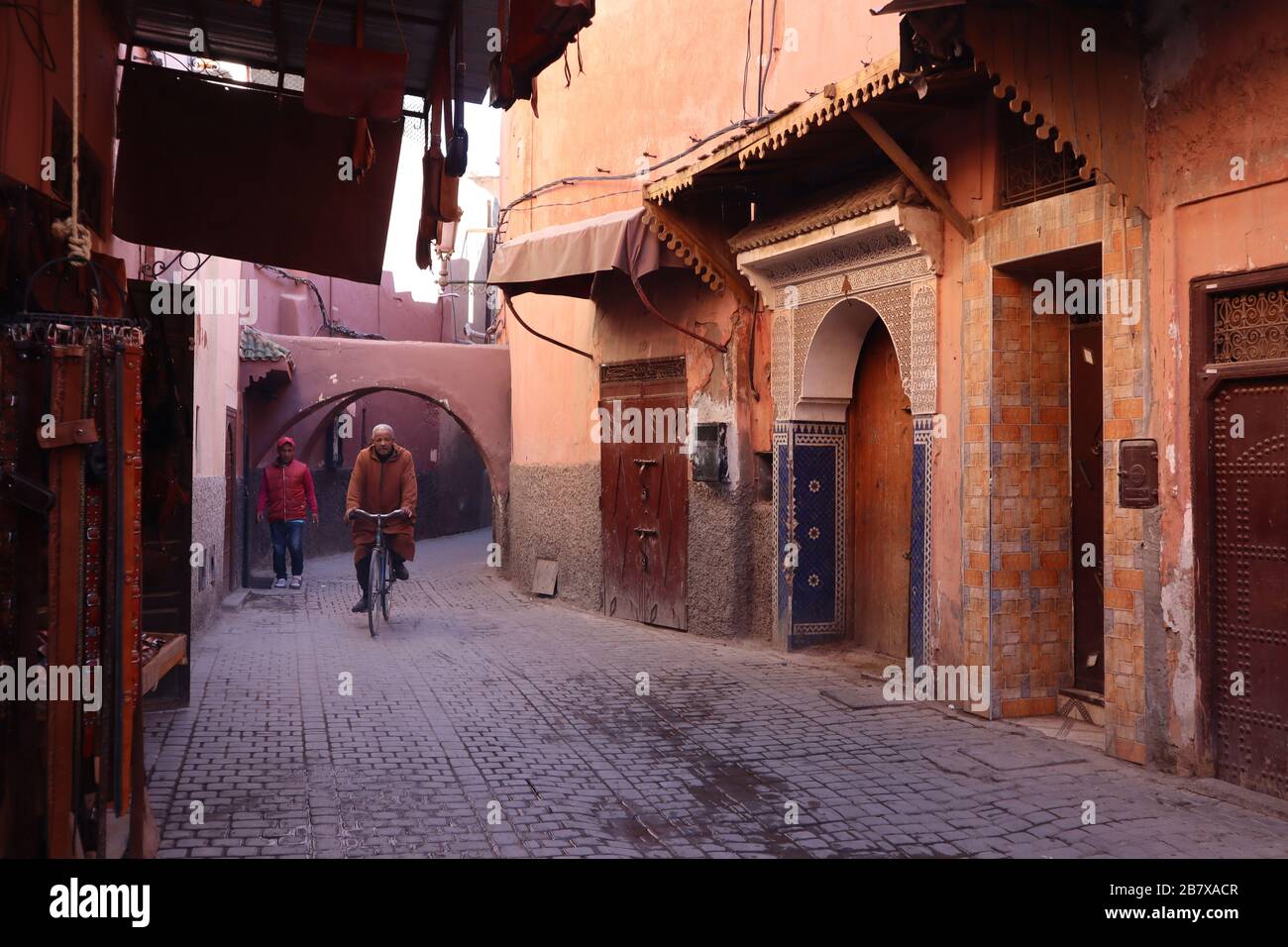 Man cycling through in The Medina Marrakesh Morocco Stock Photo