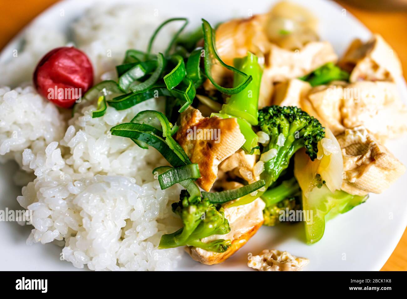 Traditional Japanese Japan plate vegetable dish with umeboshi pickled plum and tofu mushrooms with green onion negi and white rice Stock Photo