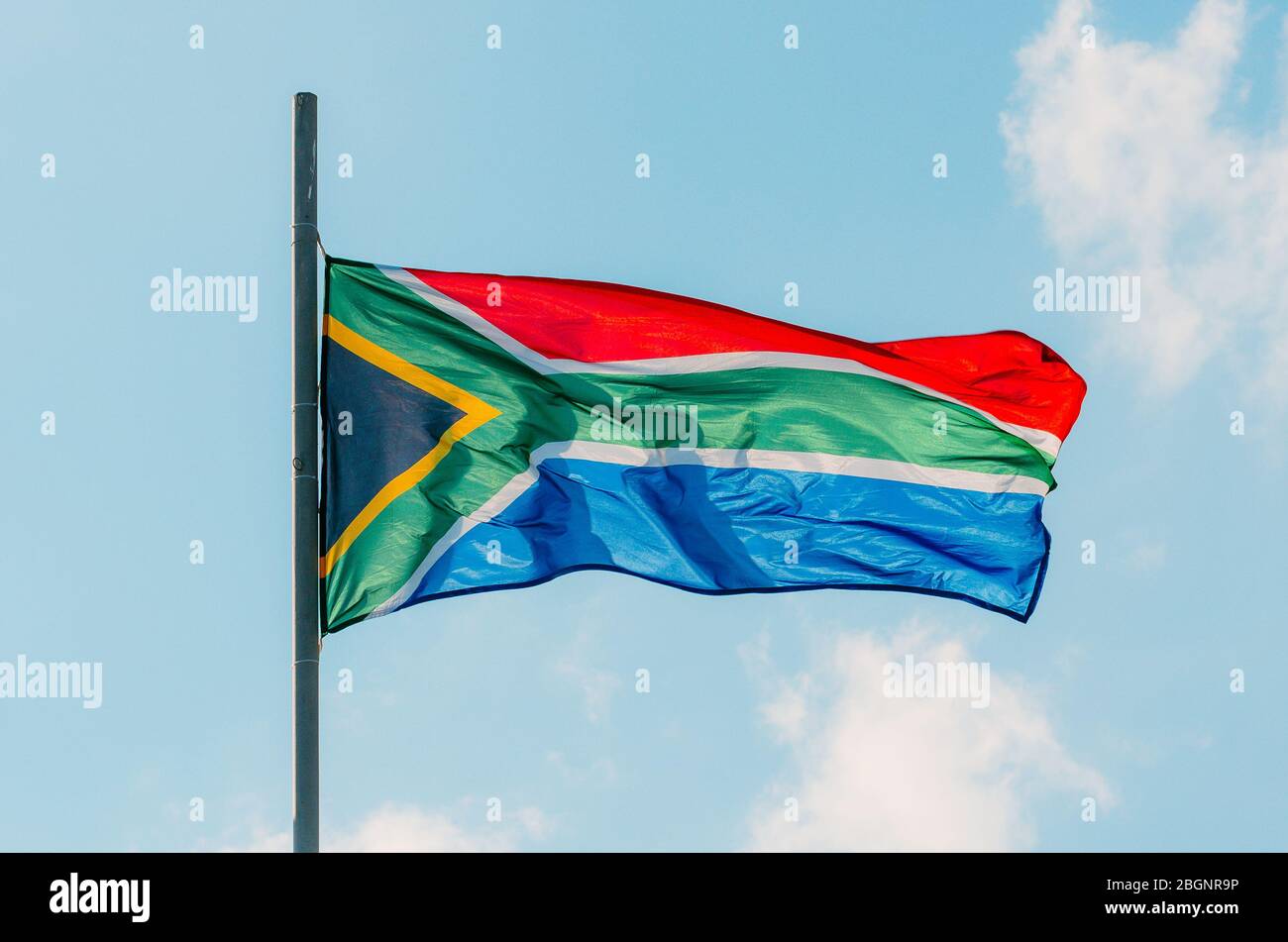 Waving colorful South Africa flag on blue sky Stock Photo