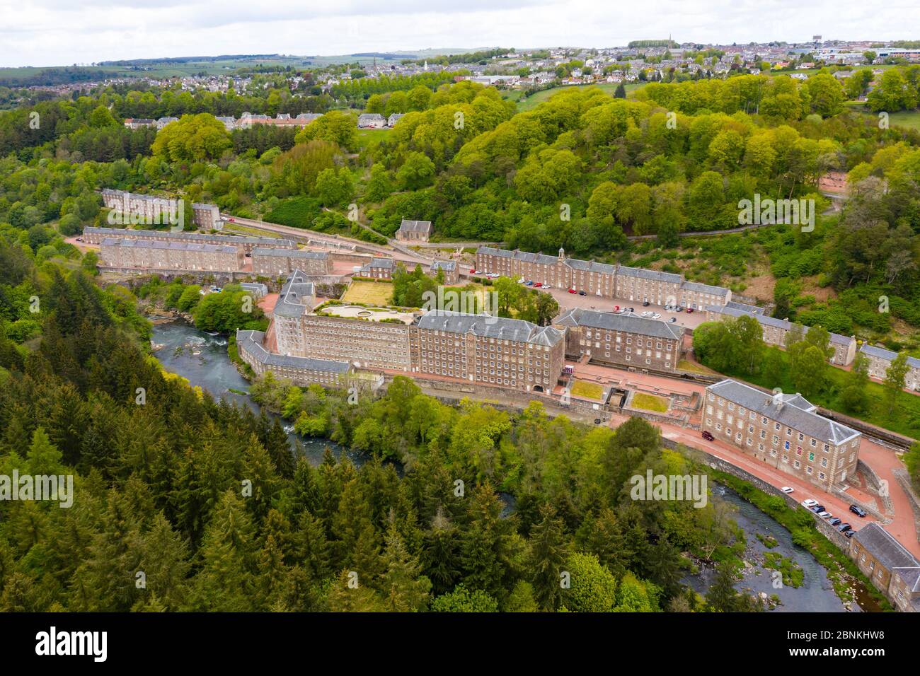 Aerial view of New Lanark World Heritage Site closed during covid-19 lockdown, beside River Clyde in South Lanarkshire, Scotland, UK Stock Photo