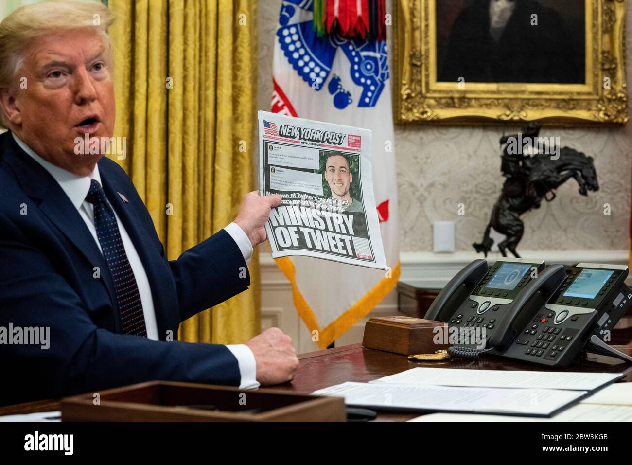 United States President Donald J. Trump, accompanied by US Attorney General William P. Barr, holds a copy of today's New York Post as he makes remarks before signing an executive order in the Oval Office of the White House in Washington, DC that will punish Facebook, Google and Twitter for the way they police content online, Thursday, May 28, 2020. Credit: Doug Mills/Pool via CNP /MediaPunch Stock Photo