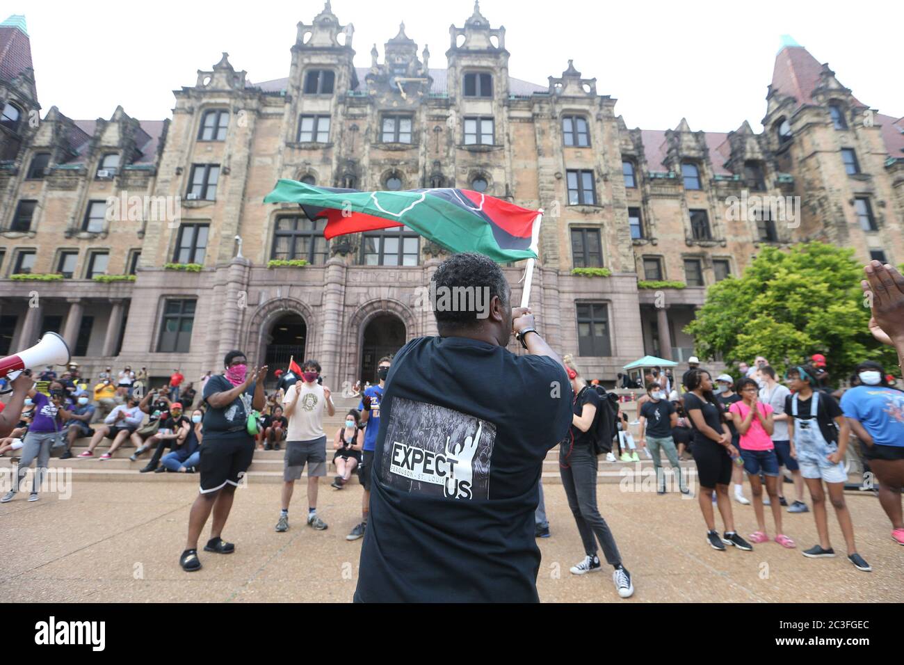 St. Louis, United States. 19th June, 2020. A Juneteenth organizer tries to pump up the crowd that has assembled outside of St. Louis City Hall, by waving a flag, in St. Louis on Friday, June 19, 2020. Originating in Texas, Juneteenth is a holiday celebrating the emancipation of those who had been enslaved in the United States. Photo by Bill Greenblatt/UPI Credit: UPI/Alamy Live News Stock Photo