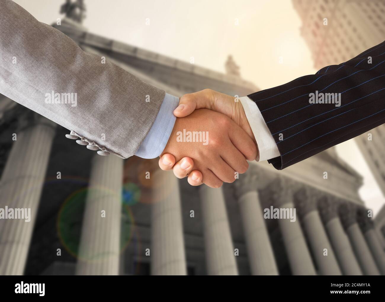 Lawyer shaking hands with businessman with court background. Concept of legal services, legal advice, law. Stock Photo