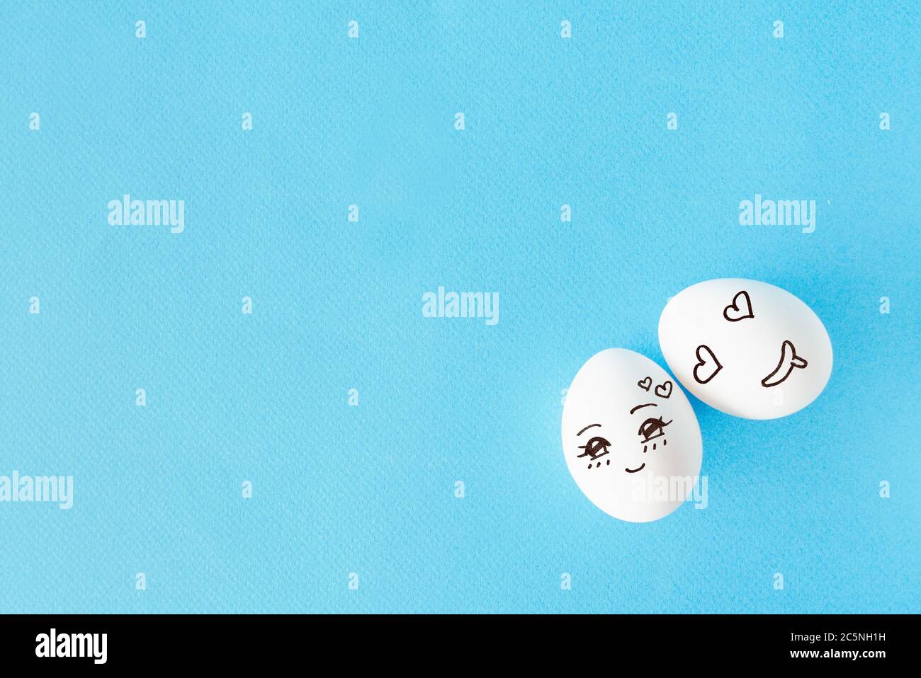 Couple eggs with happy face for love concept, blue background with empty space Stock Photo