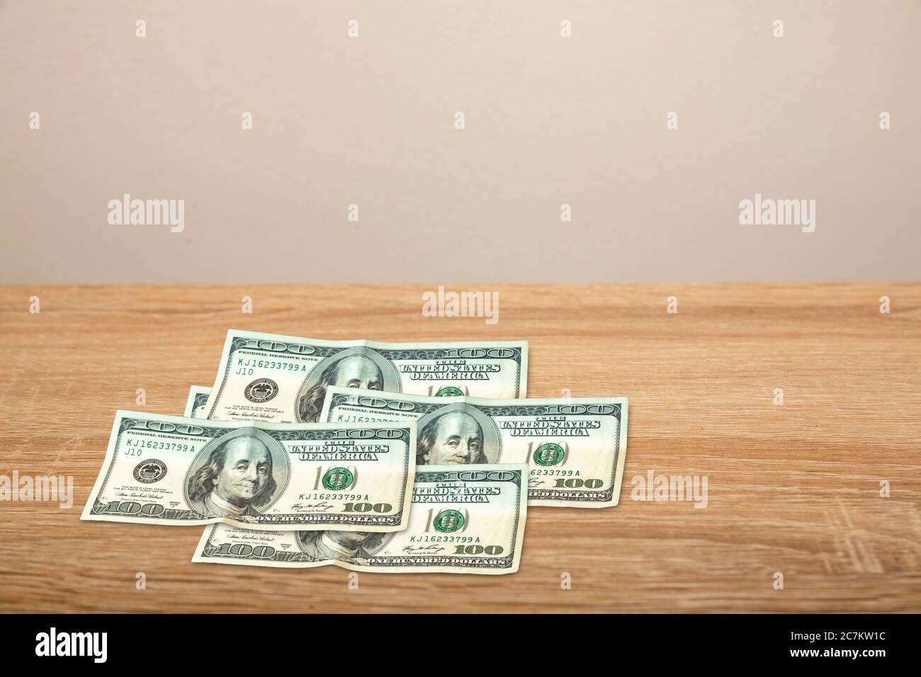 100 Dollar on wooden table Stock Photo