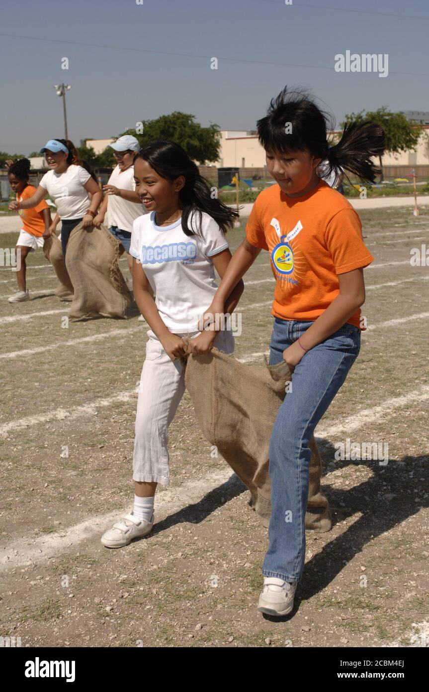 Austin Texas USA, May 2006: Fifth-grade girls compete in three-legged sack race on school playground during 'track and field day,' which traditionally marks the end of the spring semester at many area public elementary schools. ©Bob Daemmrich Stock Photo