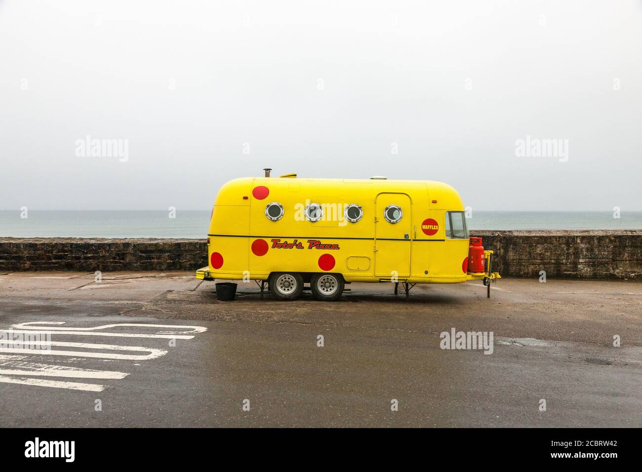 Garrettstown, Cork, Ireland. 15th August, 2020. A yellow painted Argosy Airstream Pizza trailer parker on the beach front in Garrettstown, Co. Cork, Ireland.- Credit; David Creedon / Alamy Live News Stock Photo