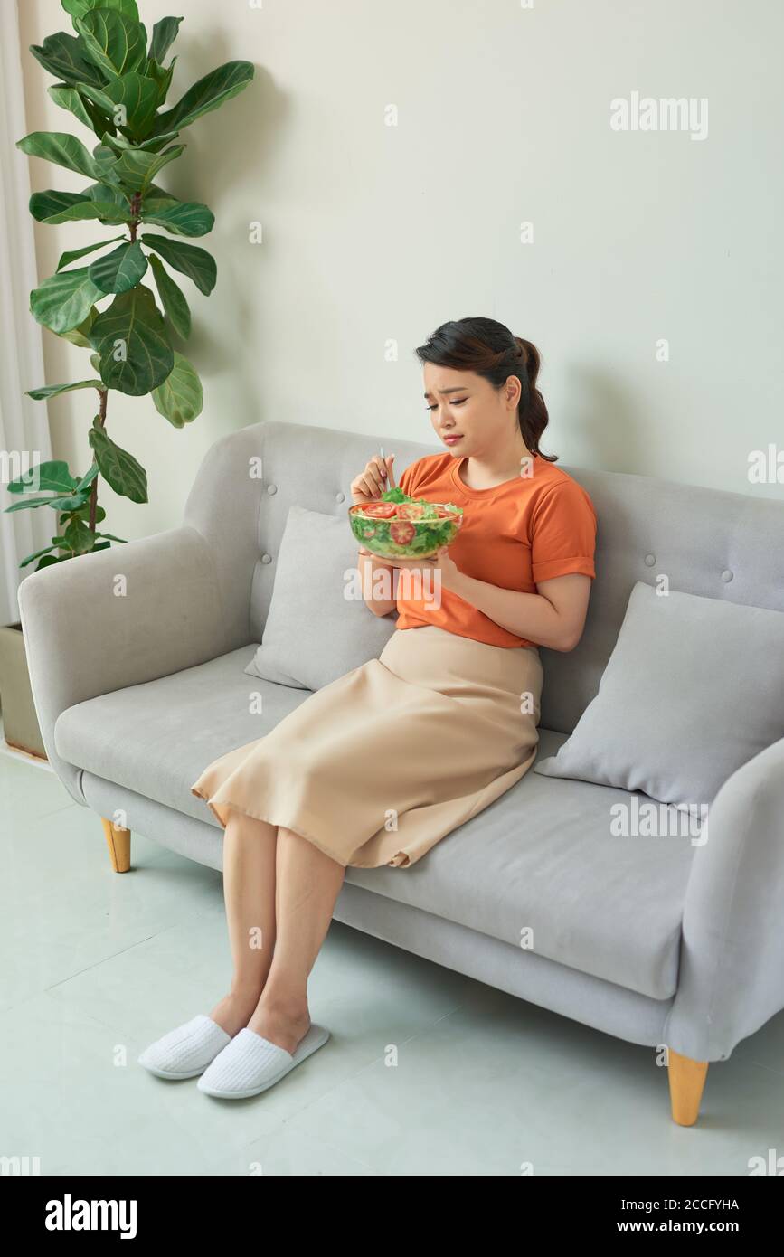 Beautiful woman on the sofa eating a healthy salad Stock Photo