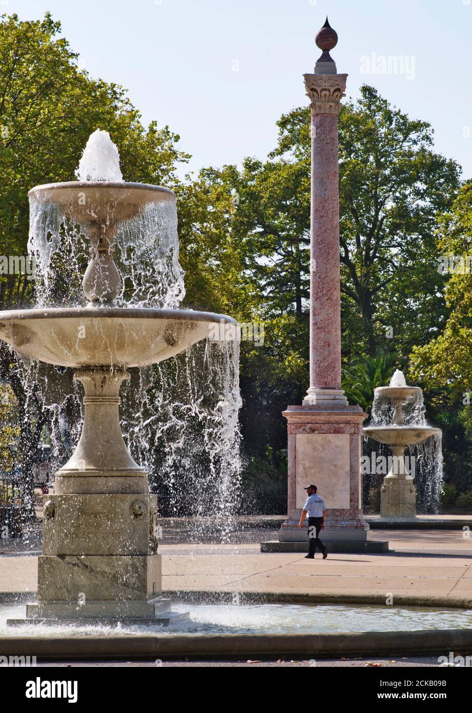 Square André Chénier, Carcassonne, Aude, France. 091520 Garden with two large fountains, a pink marble column and a security guard on patrol. Water fr Stock Photo