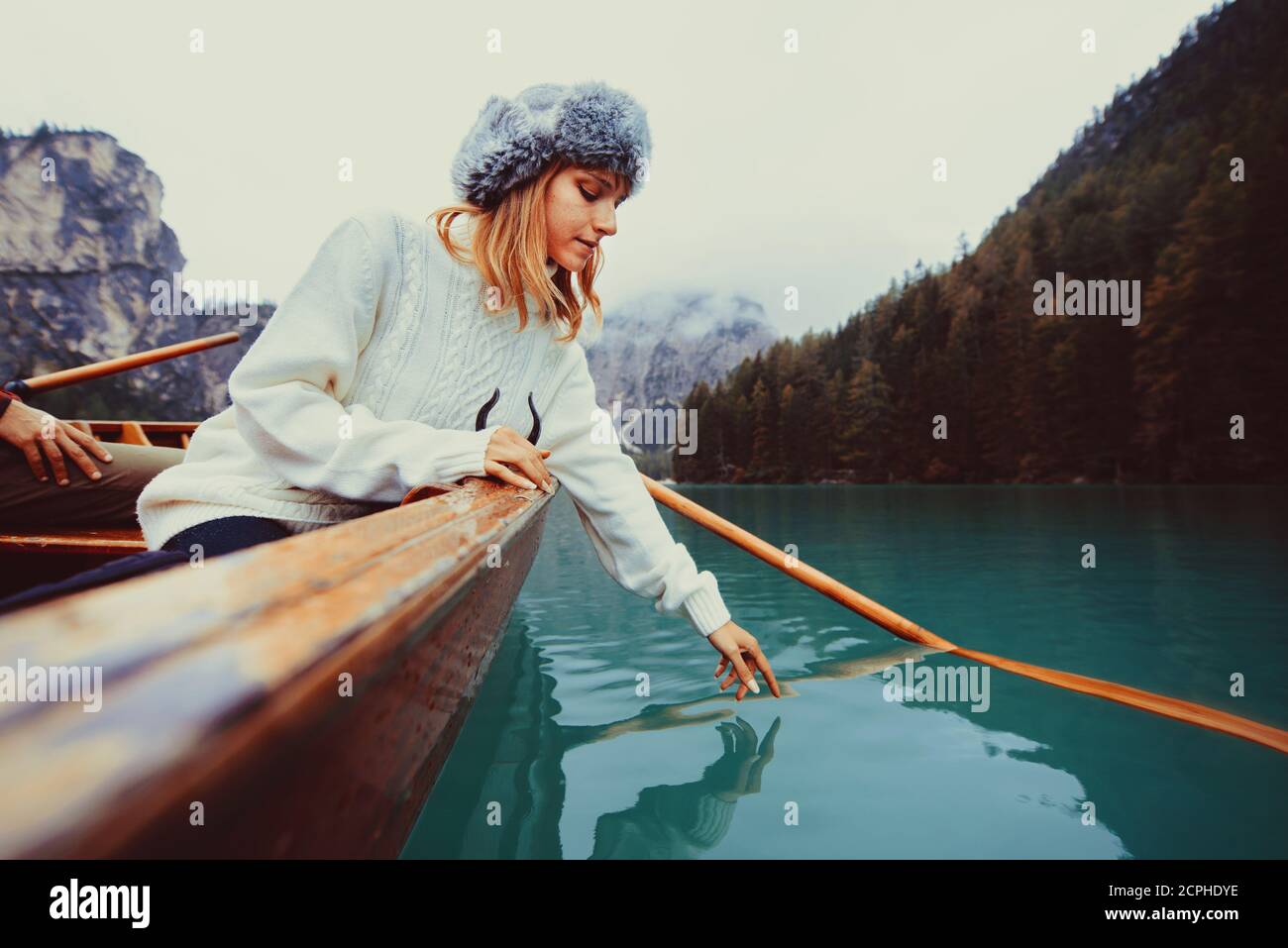 Beautiful woman visiting an alpine lake at Braies, Italy - Tourist with hiking outfit having fun on vacation during autumn foliage - Concepts about tr Stock Photo