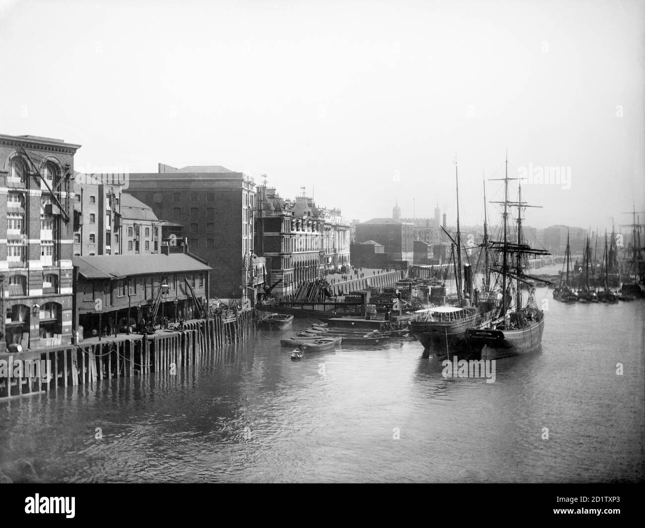 BILLINGSGATE MARKET, Lower Thames Street, City of London. Looking from London Bridge down the Thames with the Tower of London in the distance, and the old Billingsgate Market in the foreground to the left. For centuries this was the main wharf for fishing vessels to unload and moor, with the Custom House next door. Photographed by Henry Taunt in 1880. Stock Photo