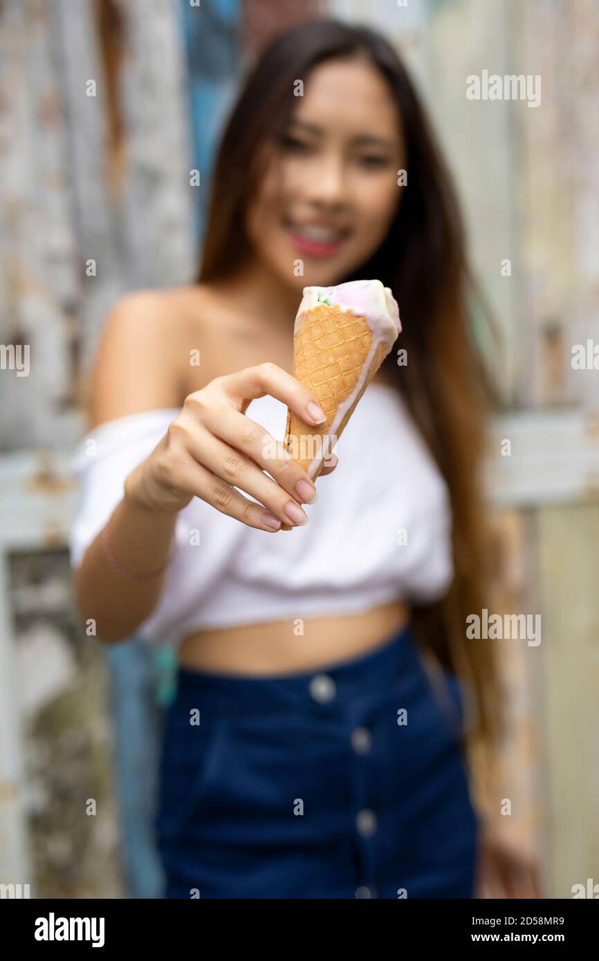 Smiling woman eating an ice-cream cone, Bali, Indonesia Stock Photo