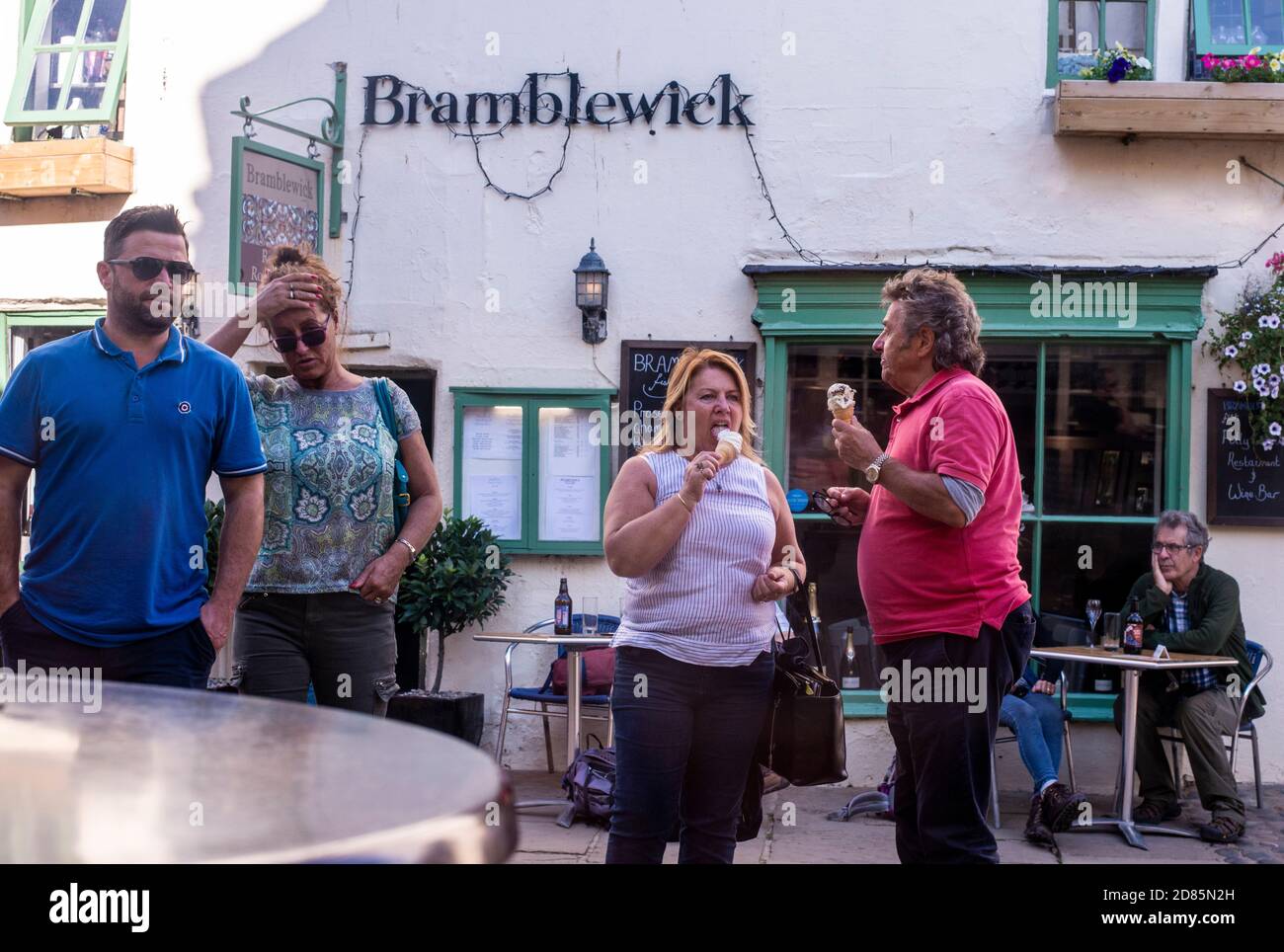 People outside cafe with ice creams, Whitby, England, UK Stock Photo