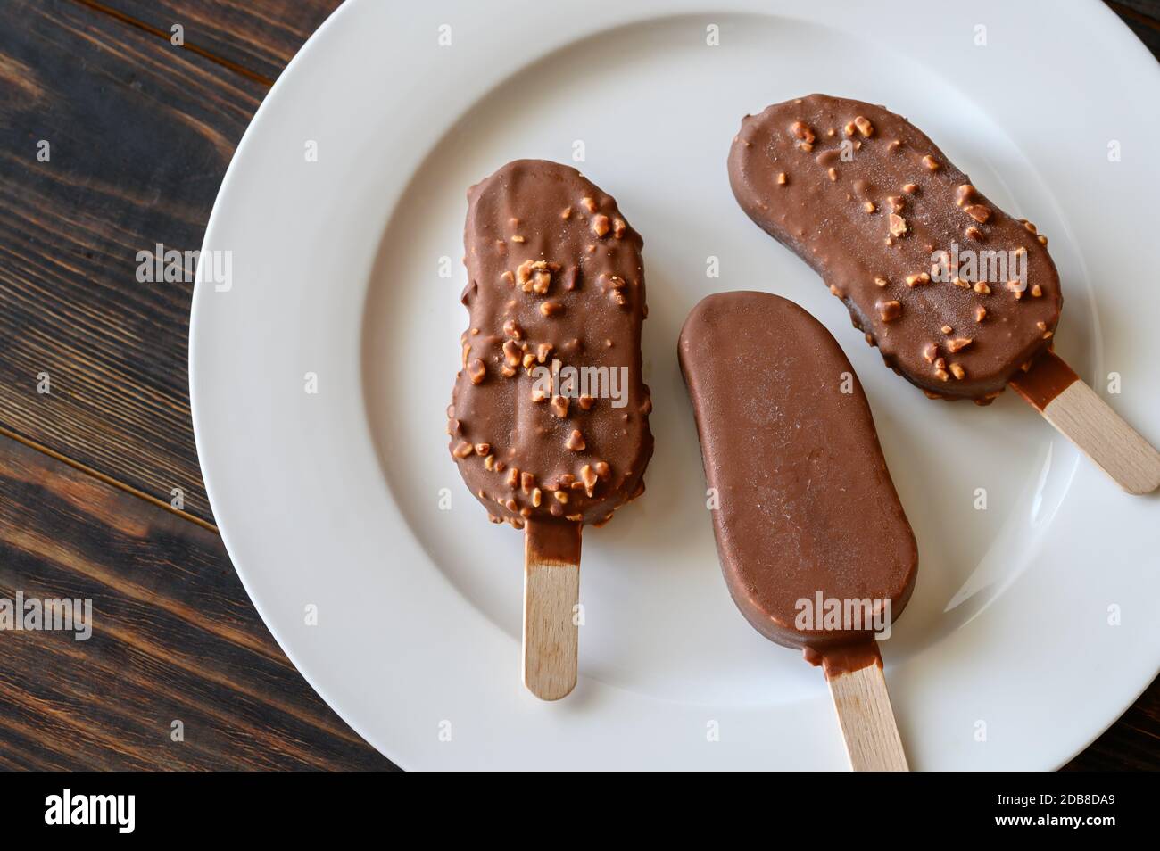 Chocolate-covered vanilla ice cream bars on the white plate Stock Photo