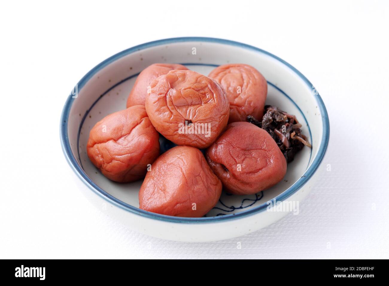 Japanese food, salted Umeboshi in a dish on white background Stock Photo