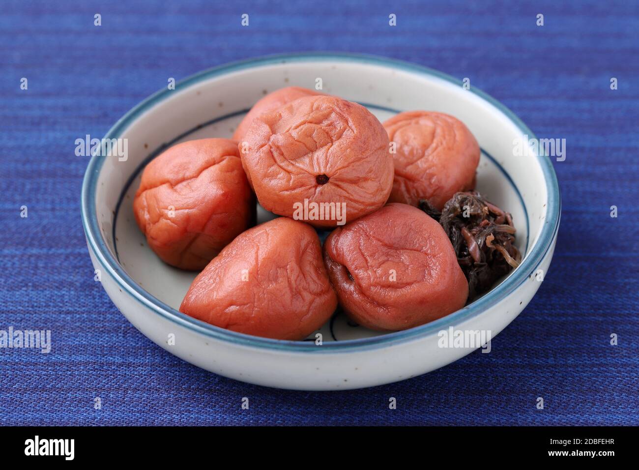 Japanese food, pickled Umeboshi in a dish on table Stock Photo