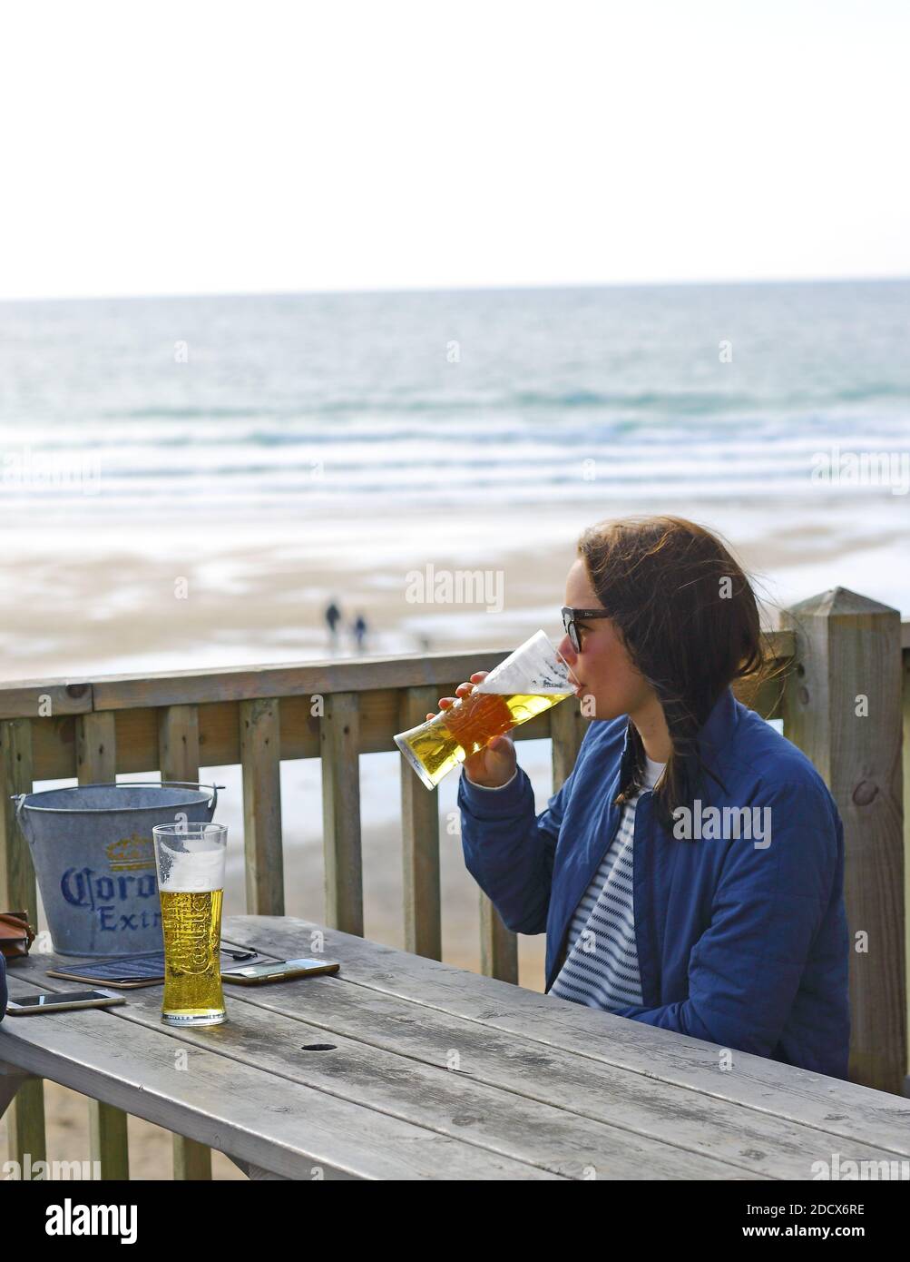 GREAT BRITAIN /Cornwall/ Newquay / Woman drinking a beer at Fistral Beach Bar and looking into the sea . Stock Photo