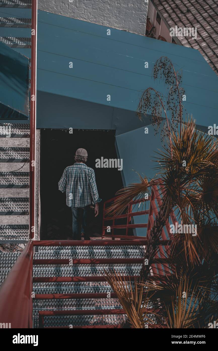 Man walking down stairs into darkness Stock Photo