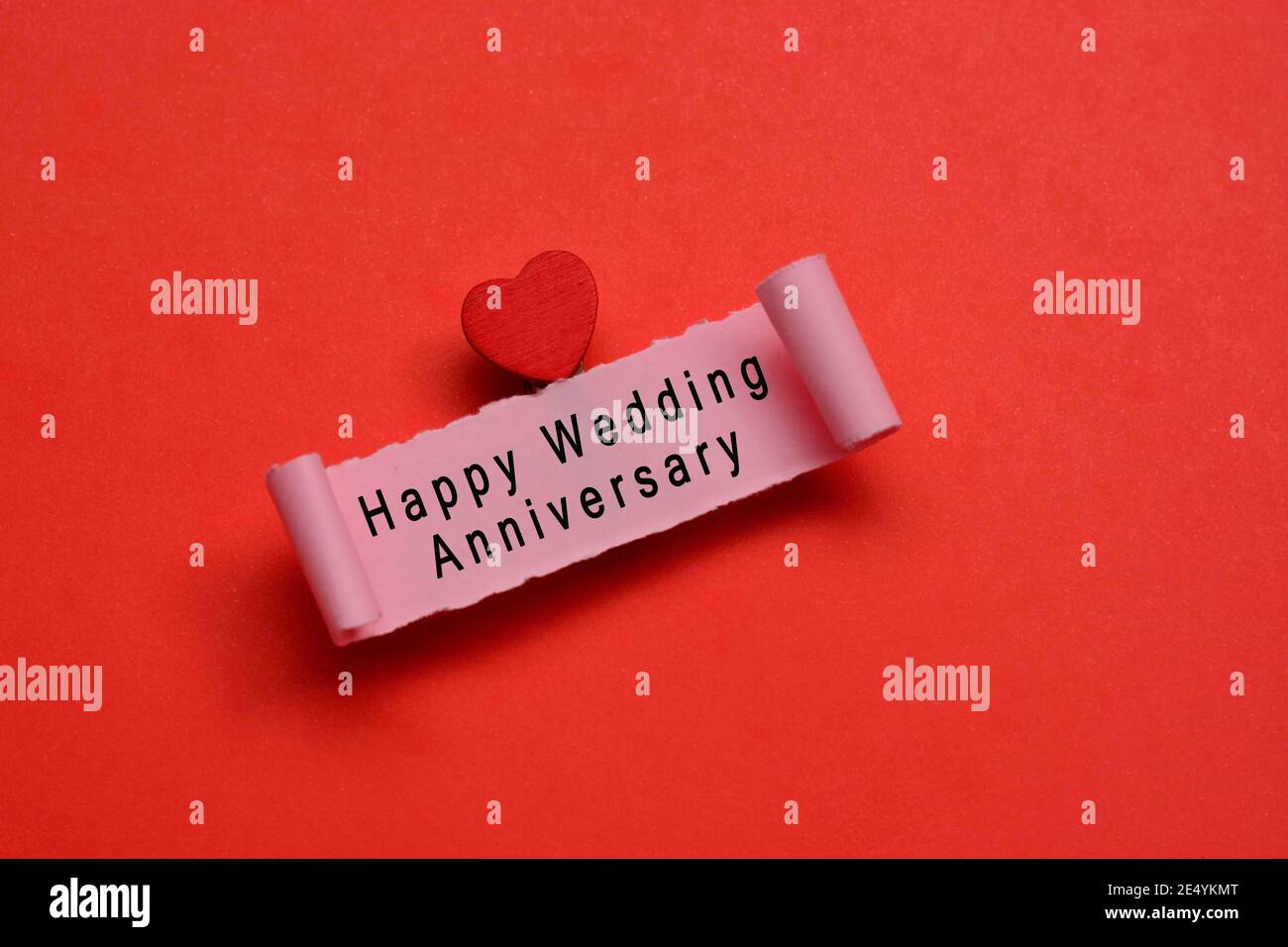 Happy wedding anniversary label on torn paper with red paper ...