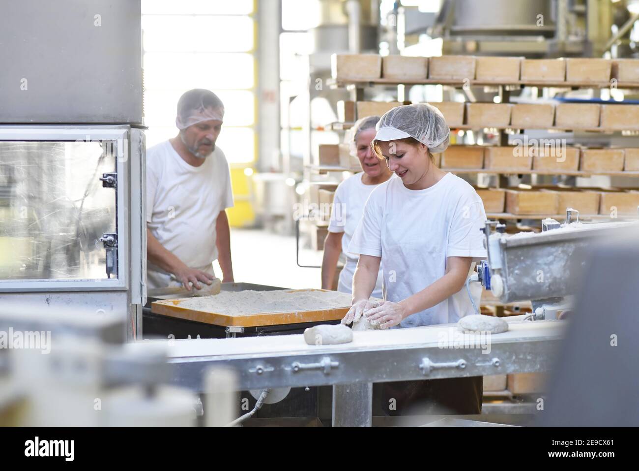 Worker in a large bakery - industrial production of bakery products on an assembly line Stock Photo