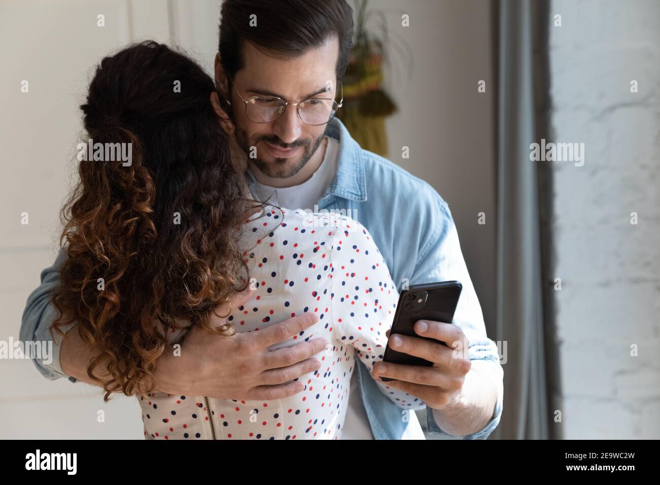 Unfair husband simulate love with wife while reading mistress messages Stock Photo