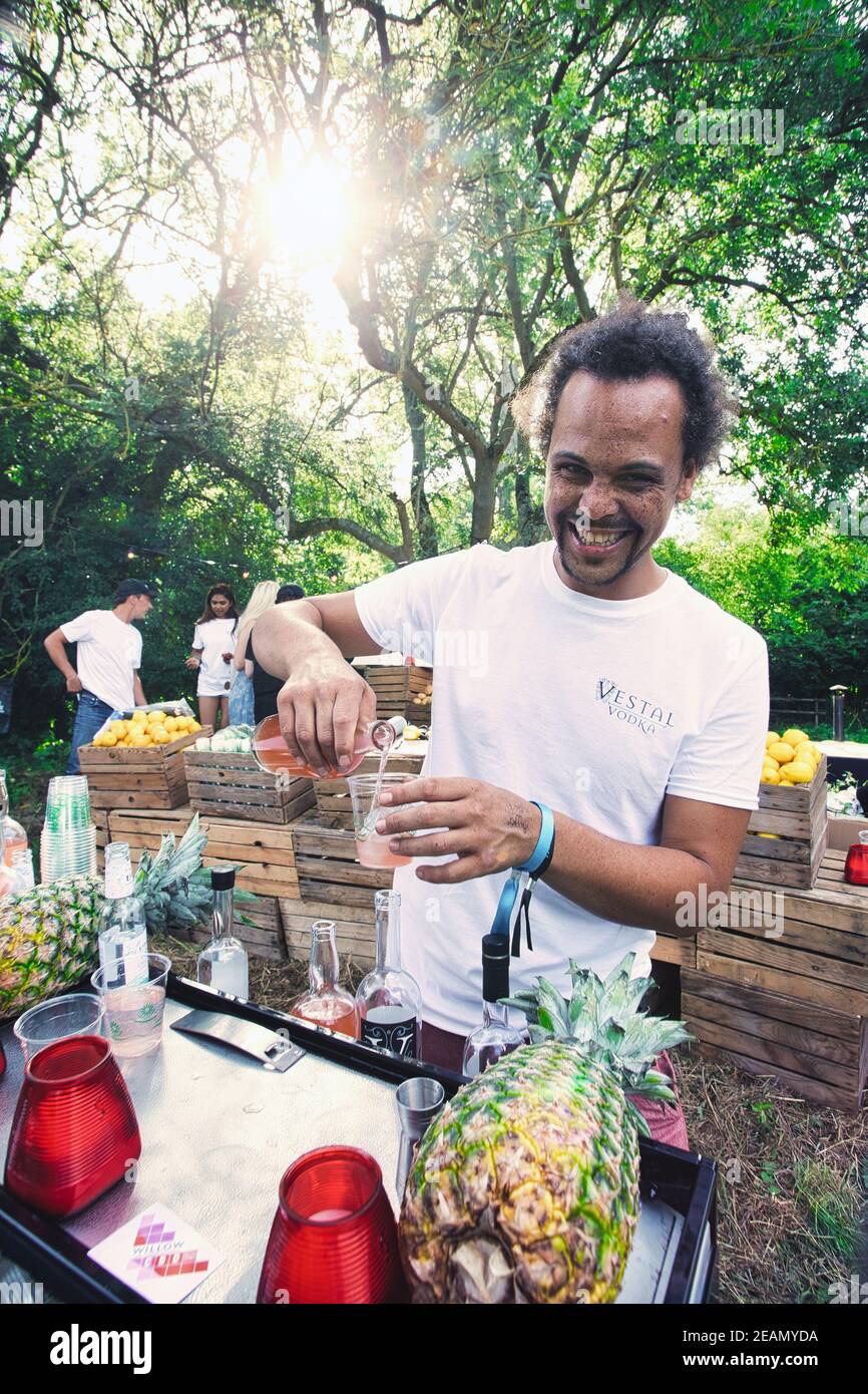 Male bar tender serves drink in outdoor bar in nature Stock Photo