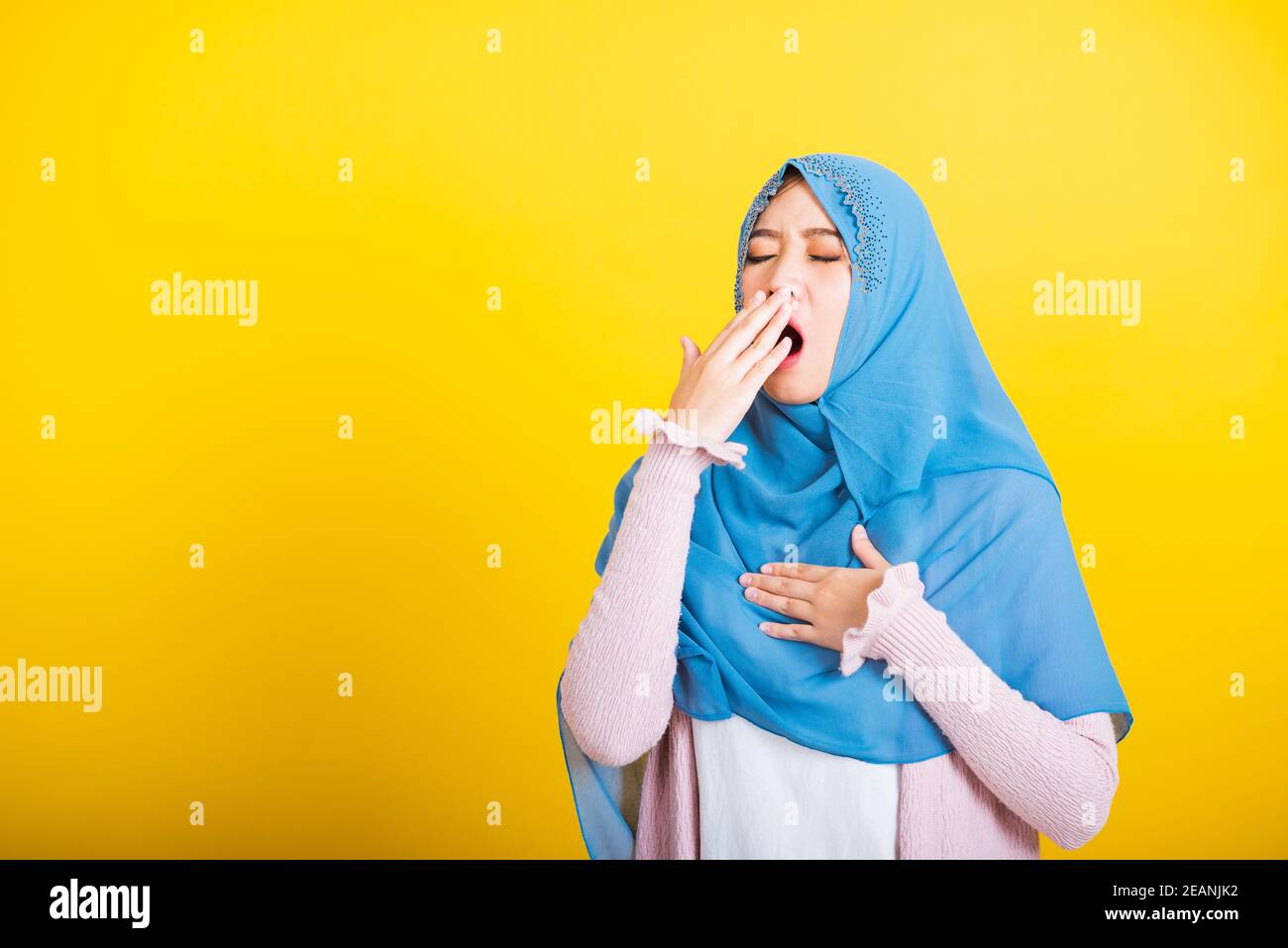 Asian Muslim Arab woman Islam wear hijab she sleepy yawning wide open mouth Stock Photo