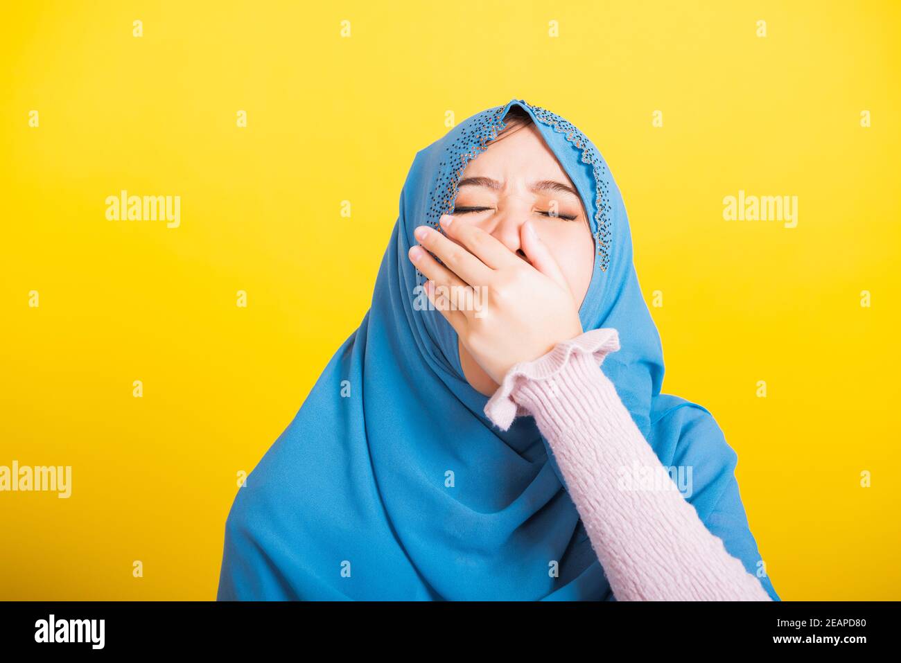 Asian Muslim Arab woman Islam wear hijab she sleepy yawning wide open mouth Stock Photo