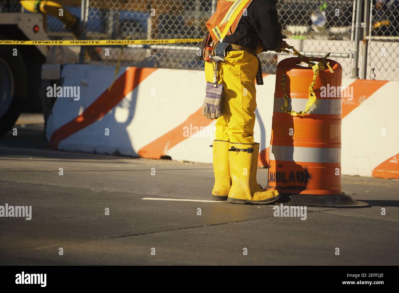 Low section view of a manual worker standing near a garbage bin Stock Photo