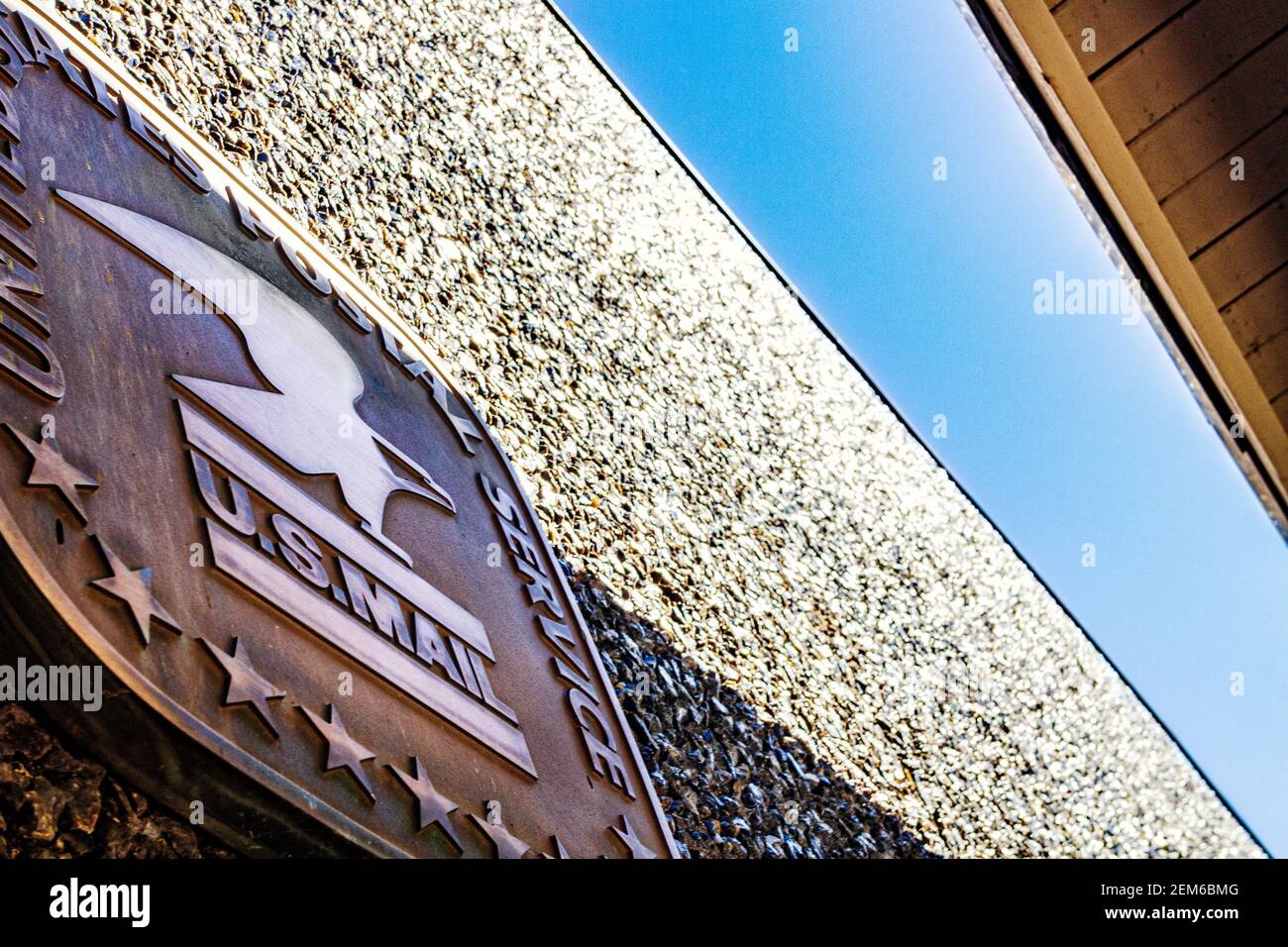 The roof, sky, and USPS logo, on the pebbledash exterior of the Grace Post Office in Asheville, NC, USA, creates an abstract design of quadrangles. Stock Photo