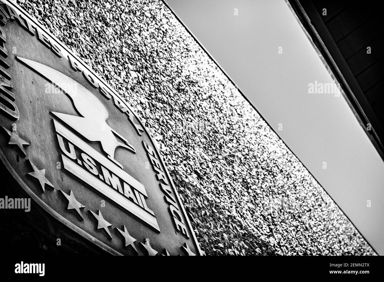 The roof, sky, and USPS logo, on the pebbledash exterior of the Grace Post Office in Asheville, NC, USA, creates an abstract design of quadrangles. Stock Photo