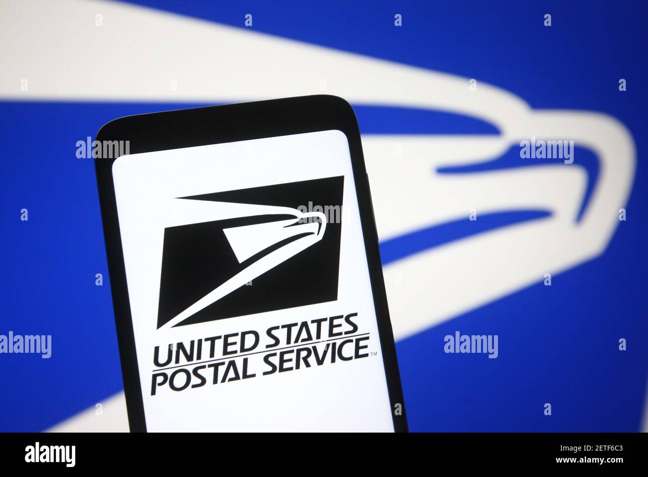 In this photo illustration the United States Postal Service (USPS) logo is seen on a smartphone and a pc screen Stock Photo