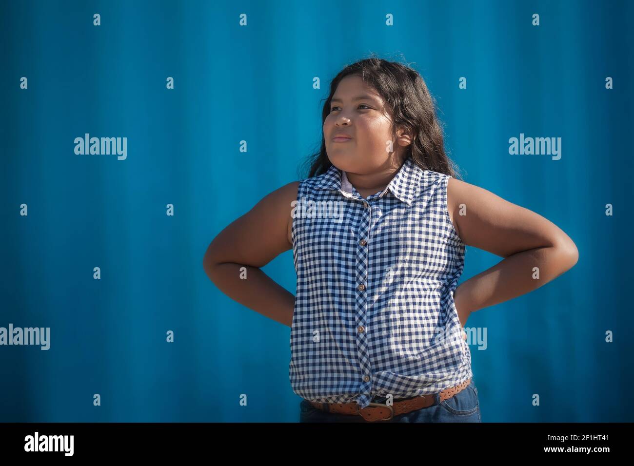 A young girl with a positive attitude, with her hands on her hips as a gesture of having an assertive personality. Stock Photo