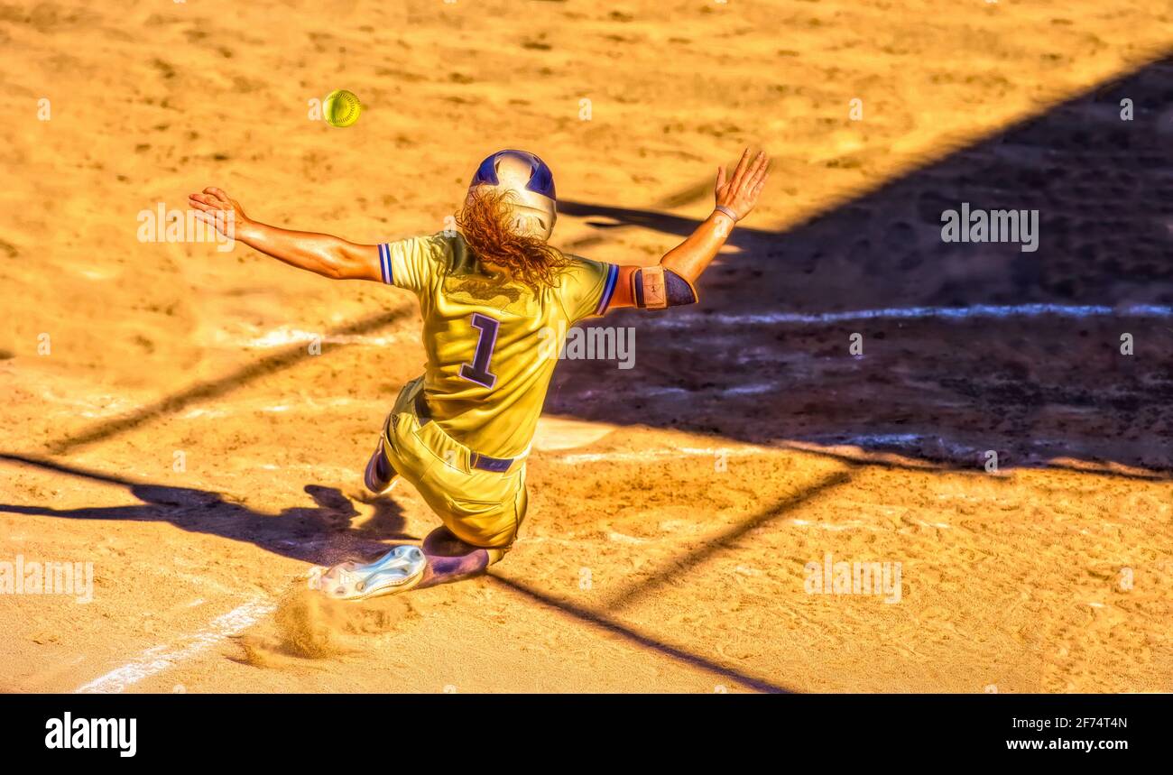 A Baseball Player Is Sliding Into Home Plate To Beat the Throw Home And Score A Run Stock Photo